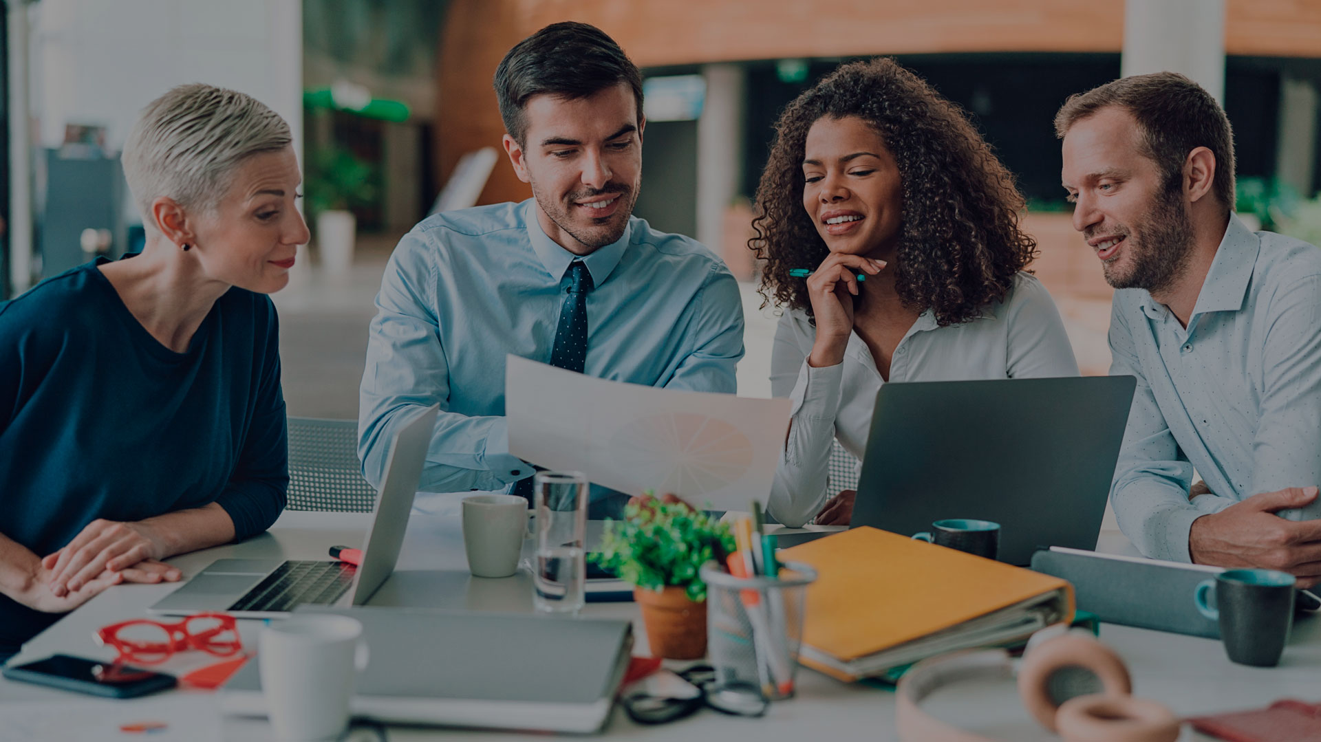 Imagem de pessoas conversando sobre algo que está em uma folha de papel